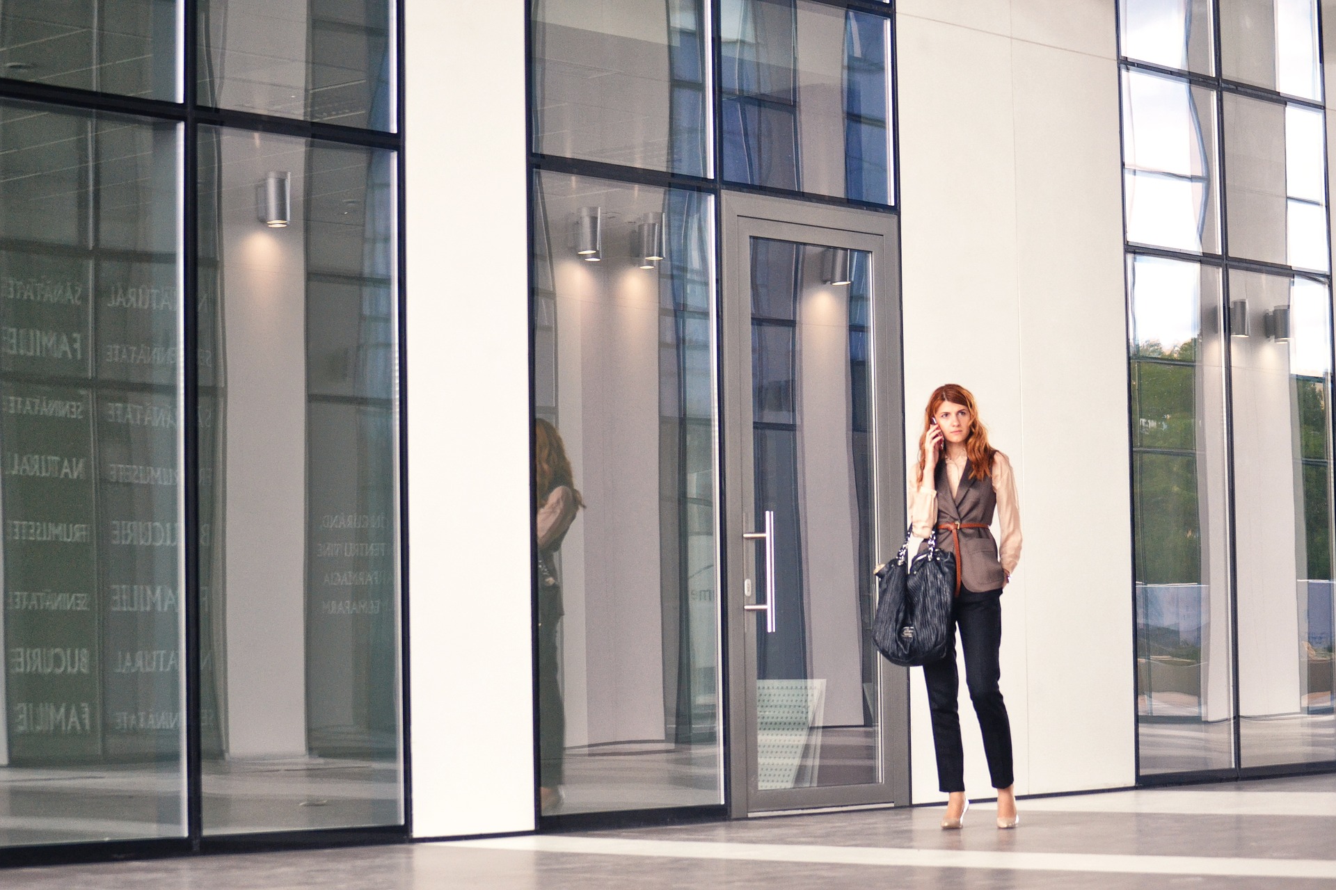 Woman standing in the common area of glass office building